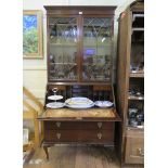 A 1930s mahogany bureau bookcase, with arched glazing bars over a sloping fall enclosing pigeon