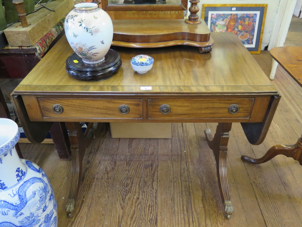 An early 19th century style mahogany sofa table, the ebony lined top over two frieze drawers on