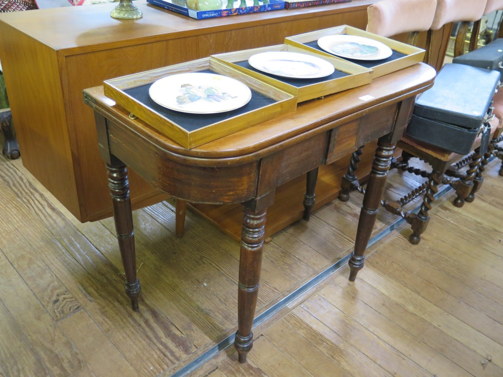 A Victorian mahogany foldover tea table, with tablet frieze on ring turned legs 91cm wide