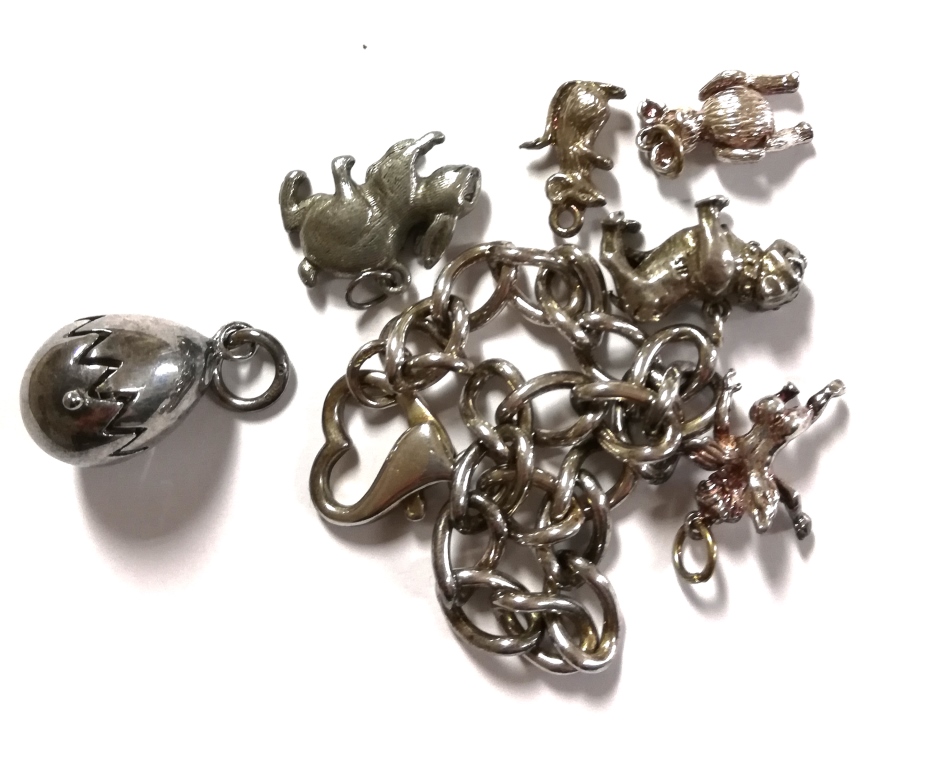 A collection of loose charms and a silver bracelet