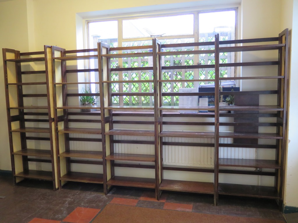 A set of stained wood stacking bookcases with canework sides, each of the ten sections with three