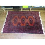 A Bokhara style rug, the red lozenges within a multiple border 116cm x 82cm and another similar in