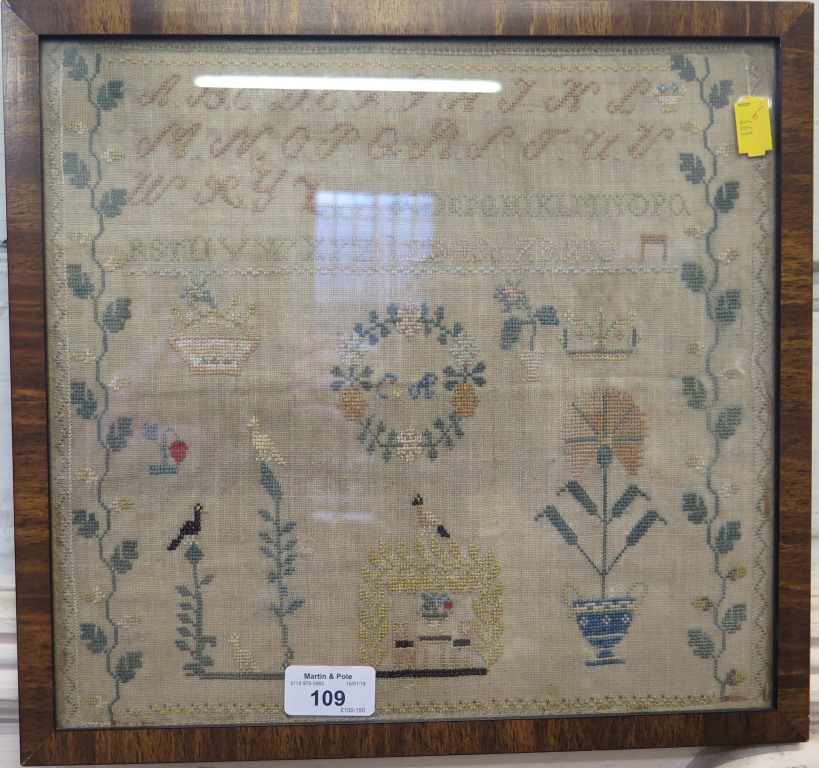 An early Victorian sampler, initialled C.A. with alphabet and numbers, vase of flowers, birds and