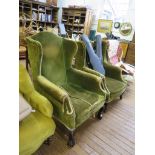 A George III style green upholstered wing armchair with acanthus carved cabriole legs and ball and