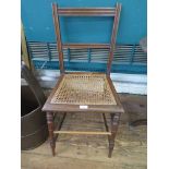 An Edwardian walnut bedroom chair with cane seat, as found