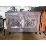 *A 17th century oak coffer, the triple panelled hinged lid over a foliate carved double panel