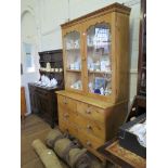 A Victorian pine kitchen dresser, the moulded cornice over a pair of glazed doors, over two short