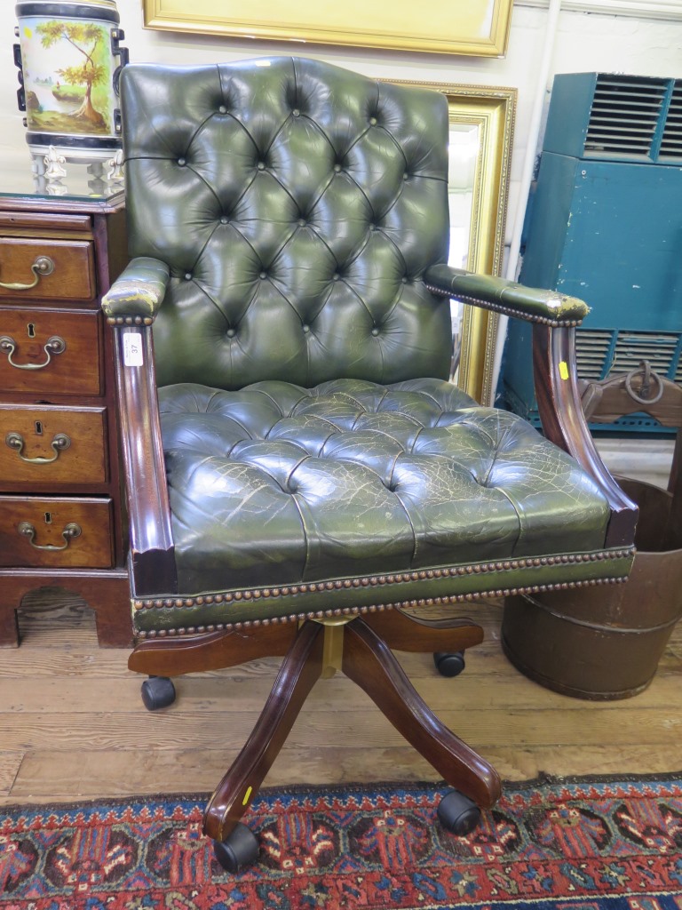 *A leather button back office armchair, adjustable and on castors