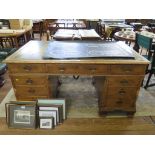*A featherbanded walnut pedestal desk, the leather top over three frieze drawers above pedestals