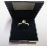 A single stone diamond ring with diamond set shoulders set in yellow gold