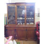 A Regency mahogany bookcase cabinet, the breakfront top with three glazed doors over a straight base