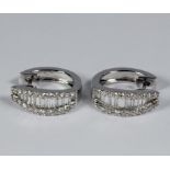 A pair of earrings, matching the previous lot, with baguette and princess cut diamonds in 18 carat