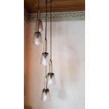 A 1960s chrome and glass five light chandelier and four other shades