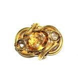 A large Victorian brooch set in gold colour metal having large cut stone to centre