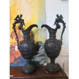 A pair of bronze classical ewers, depicting Bacchanalian scenes with grape borders, 57cm high