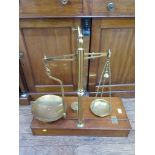 A set of brass balances, mounted on a fitted box, with troy ounce weights 70cm high