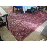 A Heriz carpet, the geometric designs on a red field with ivory spandrels in a floral border,