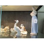A Lladro figure of a goose with goslings in a basket 10cm wide, another of a dog 15cm high and seven