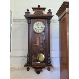 An early 20th century walnut Vienna wall clock, the shell carved pediment over fluted split columns,