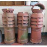 Three terracota chimney pots, the tallest 98cm high
