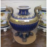 A stoneware and underglaze blue vase with lid, the twin griffin handles and lobed body on four paw