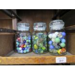 Three jars of various glass marbles