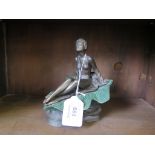 A moulded cast bronze finish model of naked young lady seated on a giant leaf
