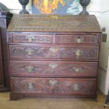 *A carved oak bureau bookcase, the double domed top enclosing pigeonholes and drawers over a married