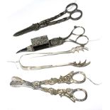 A collection of four silver plated items comprising grape scissors, sugar nips, sugar tongs and