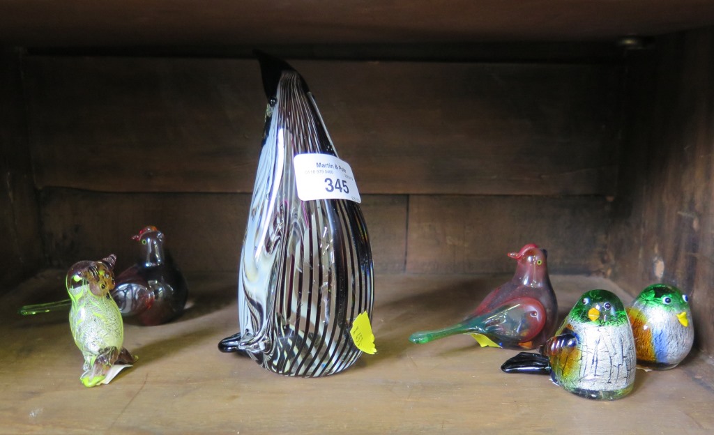 A large glass penguin paperweight together with five moulded glass birds