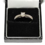 An 18 carat white gold ring set with a central diamond approximately 0.66 points and having