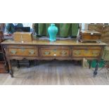 A George III oak and mahogany crossbanded dresser base, with three frieze drawers over a fret carved