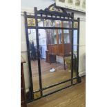 A late Victorian ebonised overmantel mirror, with gilded panels of flowers, now lacks side shelves