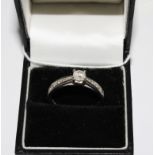 An 18 carat white gold ring set with a central diamond approximately 0.66 points and having