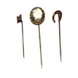 A collection of three stick pins to include a hardstone cameo head, etc