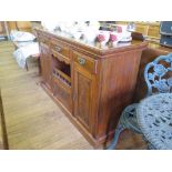 An Edwardian walnut sideboard, with three drawers over three cupboards and open space on a plinth