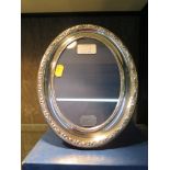 A silver oval photo frame by R. Carr with a decorative border, hallmarked Sheffield 1992,17.5cm x