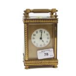 A brass cased Edwardian carriage timepiece clock, with ribbon tied frame 15.5cm high