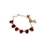 A 9 carat gold necklace set with six oval garnets