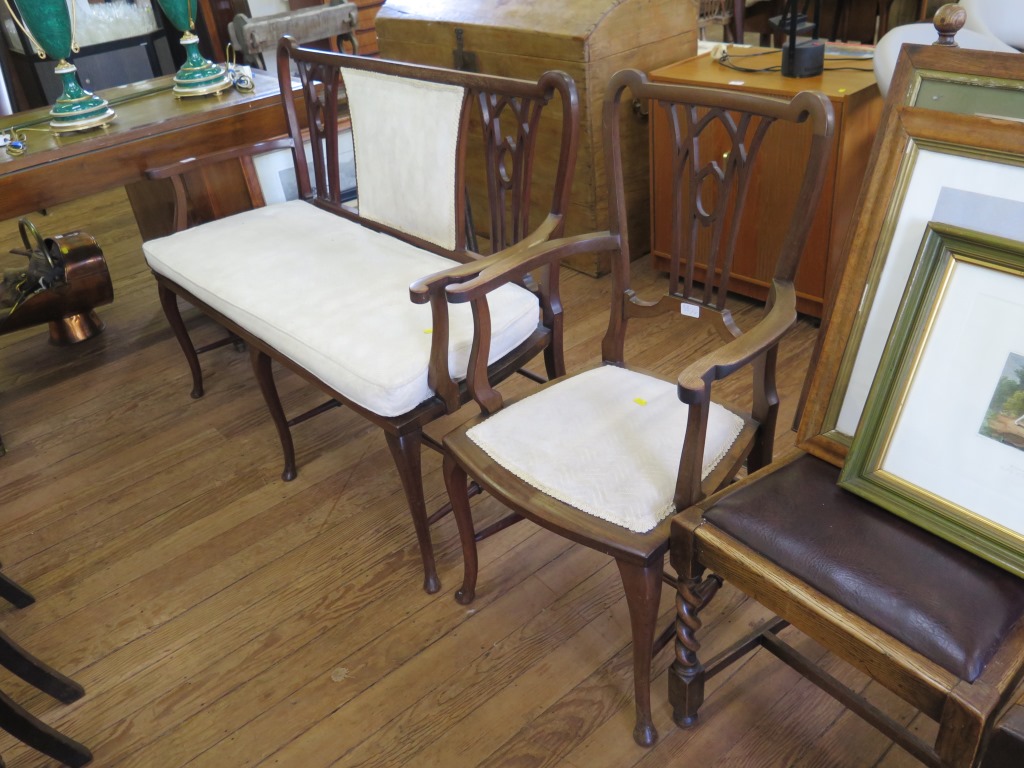 An Edwardian mahogany settee and armchair, with lancet arch design backs, padded seats and