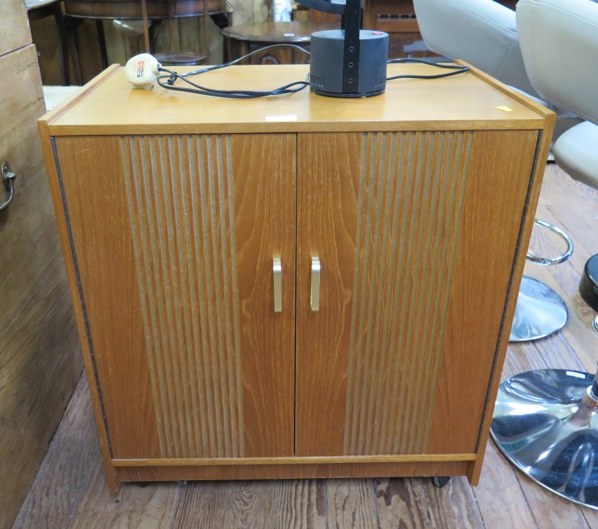 A teak hi-fi cabinet with twin doors, and compartments to hold records 63.5cm wide