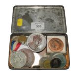 A collection of coins and medallions within a souvenir tin of the visit to Cardiff of King Edward