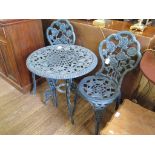 A green patinated metal garden table and two chairs, with rose head design, table 61cm diameter