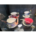 Four Franz floral design tea cups and saucers, one with hummingbird handles, another with