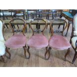 A set of three Victorian walnut balloon back chairs, the cabochon carved top rails above stuffover