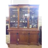 A Regency mahogany bookcase cabinet, the breakfront top with three glazed doors over a straight base