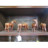 Four Chinese carved rosewood horses in various positions set with glass eyes