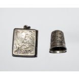 A silver stamp box and a thimble
