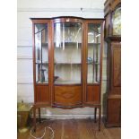 An Edwardian inlaid mahogany bowfront display case, the bowed centre flanked by cupboard doors