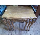 A nest of three continental oak occasional tables, with foliate carved frieze and moulded cabriole